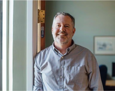 man in door smiling at vermont it services company