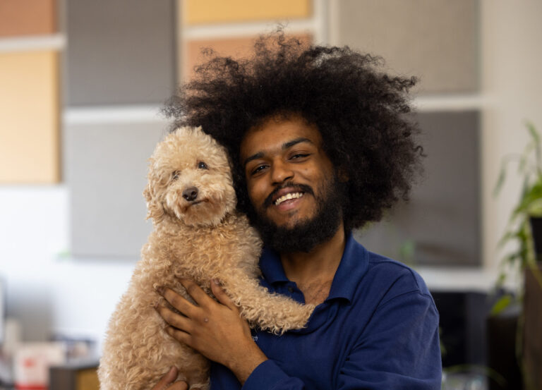 Man posing with a small white fluffy dog